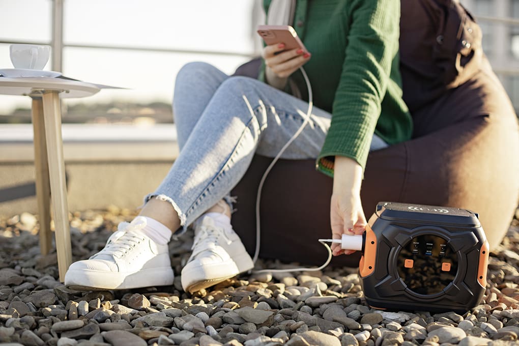 A person plugging in their smart phone in to a power station