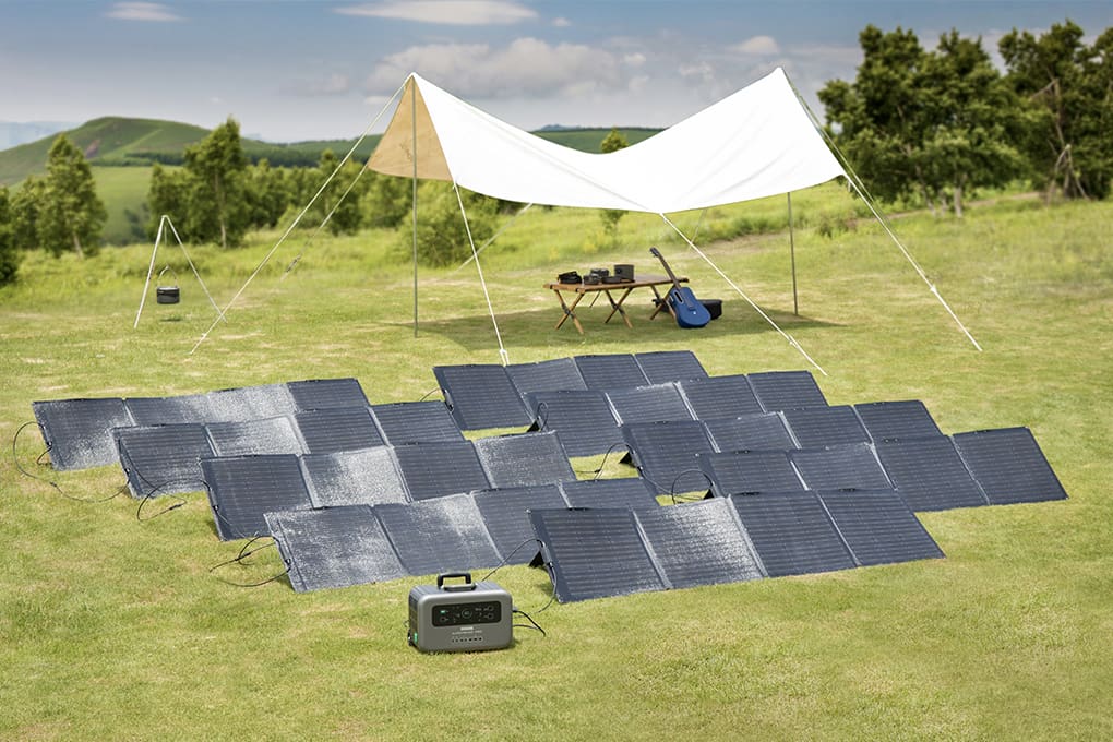 A field of portable solar panles and a tent in the background.